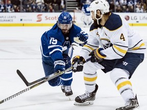 Maple Leafs centre Nic Petan (left) and Sabres defenceman Zach Bogosian (right) vie for the puck during second period NHL action in Toronto on March 2, 2019.