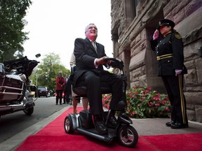 Former Ontario Lieutenant-Governor David Onley, who was tasked with reviewing the disability legislation and found the province is nowhere near meeting its stated goal of full accessibility by 2025, is saluted while arriving for his last full day in office at Queen's Park on Monday, Sept. 22, 2014. (THE CANADIAN PRESS/Darren Calabrese)