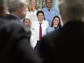 Prime Minister Justin Trudeau poses with workers as he visits the biotechnology company BioVectra Inc. in Charlottetown on Monday.