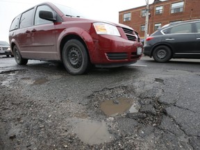 Cars try to dodge a series of potholes along O'Connor Dr. near St. Clair Ave. E. during afternoon rush hour in East York on Wednesday March 13, 2019. (Jack Boland/Toronto Sun/Postmedia Network)