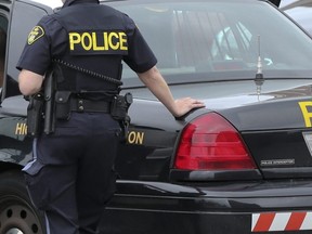 A suspect sits inside an OPP cruiser on May 28, 2014. (Dave Thomas, Toronto Sun)