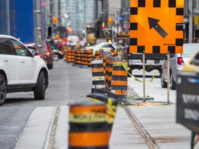Vehicle traffic is reduced to one lane due to construction  along Adelaide St W. in downtown Toronto.