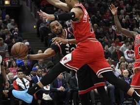 Raptors’ Norman Powell (left) passes the ball around Bulls’ Timothe Luwawu-Cabarrot during the first half in Chicago last night.  Paul Beaty/The Associated Press