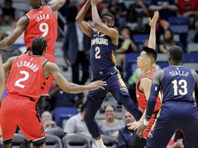 New Orleans Pelicans guard Ian Clark (2) looks to pass to forward Cheick Diallo (13) as he is guarded by Toronto Raptors center Serge Ibaka (9), forward Kawhi Leonard (2) and guard Jeremy Lin (17) in the first half of an NBA basketball game in New Orleans, Friday, March 8, 2019. (AP Photo/Scott Threlkeld) ORG XMIT: LAST108