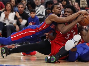 Pistons guard Ish Smith, left, and Toronto Raptors forward OG Anunoby chase the loose ball during their game on Sunday. AP Photo/Carlos Osorio)