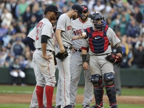 Boston Red Sox starting pitcher Chris Sale holds the ball during a mound conference in the third inning of the team's baseball game against the Seattle Mariners, Thursday, March 28, 2019, in Seattle. Sale was pulled from the game after the inning. (AP Photo/Ted S. Warren)
