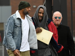 R. Kelly, centre, walks with his attorney Steve Greenberg right, and an unidentified man left, who gave him a ride after being released from Cook County Jail, March 9, 2019, in Chicago.