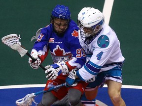 The Rock’s Latrell Harris (left) and Rochester Knighthawks’ Graeme Hossack duke it out during an NLL game earlier this season. Toronto resumes play on Saturday in Calgary. (DAVE ABEL/TORONTO SUN)