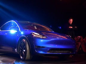 Tesla CEO Elon Musk walks beside the new Tesla Model Y as the new electric SUV is unveilaed in Hawthorne, California on March 14, 2019.. (Photo by Frederic J. BROWN / AFP)