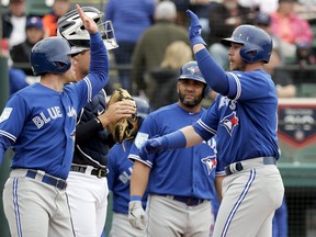 Toronto Blue Jays' Justin Smoak, right, high-fives teammate Billy McKinney after hitting a homer in the first inning against the Detroit Tigers of a spring training baseball game, Tuesday, March 5, 2019, in Lakeland, Fla. (AP Photo/John Raoux)