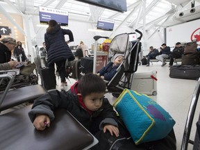 1 year old William Xie gets a catnap as his 3 year old brother James join other Air Canada  passengers affected by Wednesday's grounding of Boeing 737 MAX 8 airliners