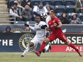 Toronto FC defender Justin Morrow (right) battles for possession of the ball with Philadelphia Union’s Raymon Gaddis during Saturday’s MLS season opener in Pennsylvania. Toronto won 3-1.  The Associated Press