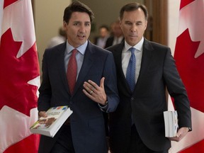 Prime Minister Justin Trudeau and Finance Minister Bill Morneau speak as they walk to the House of Commons in Ottawa, Tuesday, March 19, 2019.