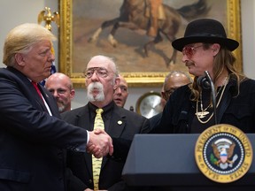 U.S. President Donald Trump shakes hands with musician Kid Rock (R) in the Roosevelt Room of the White House in Washington, D.C., in this Oct. 11, 2018, file photo.