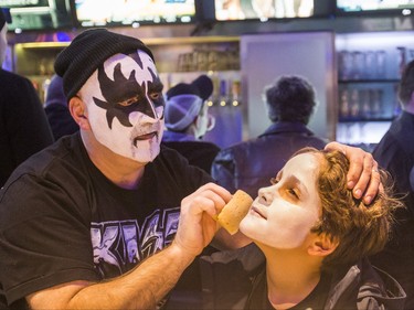 John Marques applies some make up to his nephew, Matteus da Silva, 10, ahead of the Kiss concert during a pre-show party at RealSports Bar & Grill in Toronto, Ont. on Wednesday March 20, 2019. Ernest Doroszuk/Toronto Sun/Postmedia