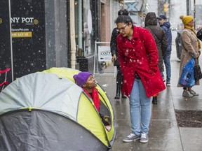 Cannabis attorney Caryma Sa’d speaks with Marie Kamara, who's staked out a spot along the sidewalk in front of the The Hunny Pot Cannabis Co. on Queen St. W., near University Ave. in Toronto, Ont. on Sunday March 31, 2019.