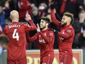 Toronto FC's Alejandro Pozuelo celebrates with teammates Michael Bradley (left) and Nick DeLeon (right) after scoring against New York City last week. (THE CANADIAN PRESS)