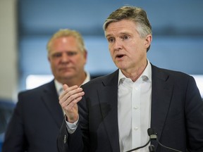 Rod Phillips addresses media as Doug Ford listens on April 1, 2019.