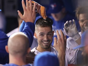 Randal Grichuk of the Toronto Blue Jays is congratulated by teammates in the dugout after hitting a solo home run in the eighth inning during MLB game action against the Baltimore Orioles at Rogers Centre on April 3, 2019 in Toronto, Canada.