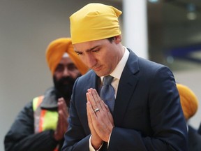 Prime Minister Justin Trudeau bows his head before speaking at the Khalsa Diwan Society Sikh Temple before marching in the Vaisakhi parade, in Vancouver on Saturday April 13, 2019. (The Canadian Press)