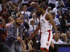 Toronto Raptors Kawhi Leonard SF (2) gets a low five from Drake as he exits the game during the second half in Toronto, Ont. on Saturday April 27, 2019. Jack Boland/Toronto Sun/Postmedia Network