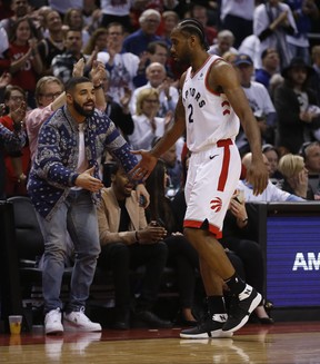Toronto Raptors Kawhi Leonard gets a low five from Drake on Saturday April 27, 2019.