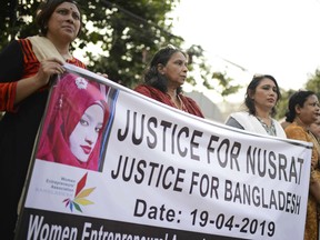 Protesters hold placards and gather to demand justice for an 18-year-old woman who was killed after she was set on fire for refusing to drop sexual harassment charges against her Islamic school's principal, in Dhaka, Bangladesh, Friday, April 19, 2019. (AP Photo/Mahmud Hossain Opu)