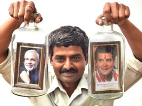 Artist Basavaraj holds portraits of  Indian Prime Minister Narendra Modi, left, and Rahul Gandhi — frontrunners in India's 2019 general election.