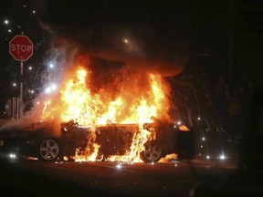 A car burns after petrol bombs were thrown at police in the Creggan area of Derry, in Northern Ireland, Thursday, April 18, 2019.