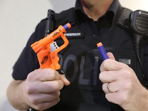 Const. Ryan Anderson of Halton Regional Police holds a Nerf gun used by local teens playing the "Assassins Game" on Thursday, April 18.