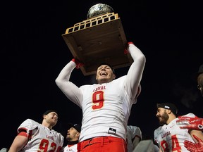 Laval University Rouge et Or's Mathieu Betts raises the trophy as they celebrate victory against Western University Mustang at the Vanier Cup final Saturday, Nov. 24, 2018 in Quebec City.