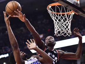 Orlando Magic forward Amile Jefferson  and Toronto Raptors forward Chris Boucher battle for the ball during second half NBA basketball action in Toronto on Monday, April 1, 2019.