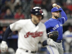 Toronto Blue Jays relief pitcher Tim Mayza, right, throws to first base to get Cleveland Indians' Eric Stamets, left, out in the seventh inning of a baseball game, Thursday, April 4, 2019, in Cleveland. Stamets was safe at first base on a throwing error by Mayza. The Indians won 4-1.