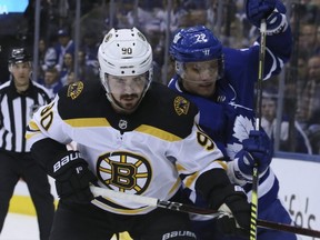 Maple Leafs defenseman Nikita Zaitsev (right) battles Bruins left wing Marcus Johansson (left) during NHL playoff action in Toronto on Wednesday, April 17, 2019.