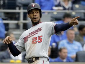 Minnesota Twins' Byron Buxton points to teammate Eddie Rosario after scoring on a Rosario's single during the ninth inning of a baseball game against the Kansas City Royals on April 3, 2019. (CHARLIE RIEDEL/AP)