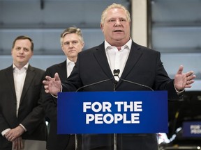 Premier Doug Ford gives remarks at a car dealership alongside MPP Jeff Yurek and provincial Environment Minister Rod Phillips, in Toronto, on Monday, April 1, 2019. THE CANADIAN PRESS/Christopher Katsarov