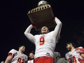Laval University Rouge et Or's Mathieu Betts raises the trophy as they celebrate victory against Western University Mustang at the Vanier Cup final Saturday, Nov. 24, 2018 in Quebec City. (THE CANADIAN PRESS/Jacques Boissinot)