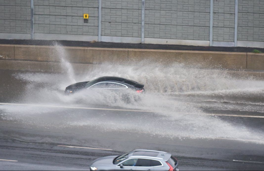 A car drives through a flooded portion of the westbound 401 near Avenue Rd. on April 26, 2019.  Heavy rain caused localizing ponding and flooding throughout the Toronto area