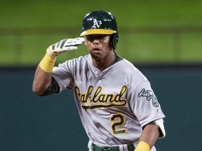 Khris Davis of the Oakland Athletics salutes third base coach Matt Williams while circling the bases after hitting a solo home run on April 12, 2019. (JEFFREY McWHORTER/
AP)