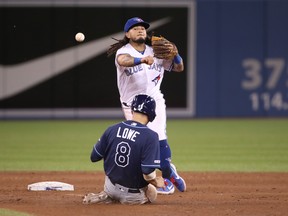 Blue Jays’ Freddy Galvis turns a double play in the ninth inning as Tampa Bay’s Brandon Lowe slides into second at Rogers Centre yesterday. The Rays won 8-4. (Getty images)