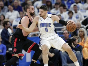 Raptors’ Marc Gasol defends against Magic’s Nikola Vucevic during Game 3 on Friday night in Orlando. (AP PHOTO)
