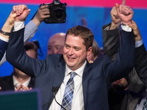 Andrew Scheer (C), newly elected leader of the Conservative Party of Canada, celebrates with his rival Maxime Bernier (L) following his win at the party's convention in Toronto, Ontario, May 27, 2017. / AFP PHOTO / Geoff Robins        (Photo credit should read GEOFF ROBINS/AFP/Getty Images)