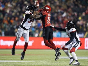 Stampeders' Eric Rogers (centre) battles the Redblacks' Kyries Hebert (left) and Rico Murray (right) during second half Grey Cup action at Commonwealth Stadium in Edmonton, Nov. 25, 2018.