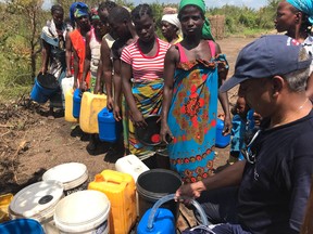 GlobalMedic volunteer Mathan Karunaratnam, a City of Toronto water treatment plant technician, distributes purified water in Mozambique. (GlobalMedic)