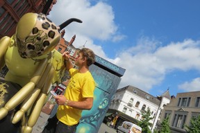 Stuart Roberts fixes paint on a large golden bee sculpture on Stevenson Square, Manchester. (Ian Robertson)
