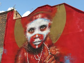 During the first Cities of Hope street art convention in 2016, Manchester artist Dale Grimshaw used his Globalization, 'Free West Papau' and '2 Worlds' themes to paint the side of a Spear Street building with the image of a young Papua New Guinea child wearing body paint and facing a harsh future. (Ian Robertson)