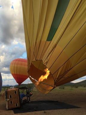 A crew member from Hot Air Expeditions blows heated air into a balloon in preparation for takeoff. ROBIN ROBINSON/SPECIAL TO POSTMEDIA NETWORK