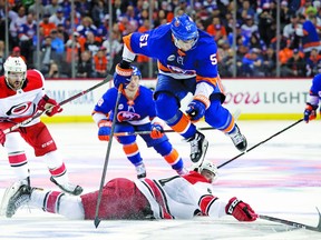 New York Islanders center Valtteri Filppula (51), of Finland, leaps over Carolina Hurricanes center Clark Bishop, bottom, while competing for the puck during the second period of Game 1 of an NHL hockey second-round playoff series, Friday, April 26, 2019, in New York. (AP Photo/Julio Cortez)