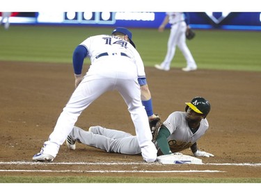 Toronto Blue Jays Justin Smoak 1B (14) tries to tag Oakland Athletics Jurickson Profar during the fifth inning in Toronto, Ont. on Friday April 26, 2019. Jack Boland/Toronto Sun/Postmedia Network