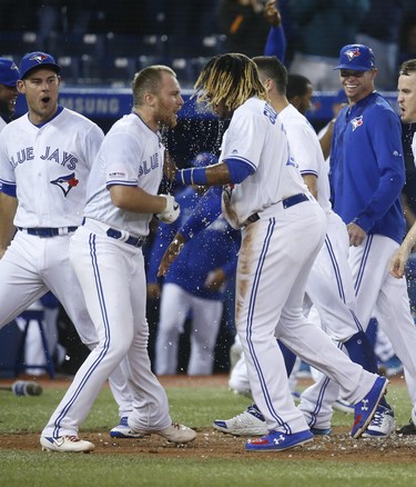 Blue Jays Brandon Drury 3B  is congratulated by Blue Jays Vlad Guerrero Jr. after hitting a two-run homer In the ninth inning on Friday night. (Jack Boland/Toronto Sun/Postmedia Network)